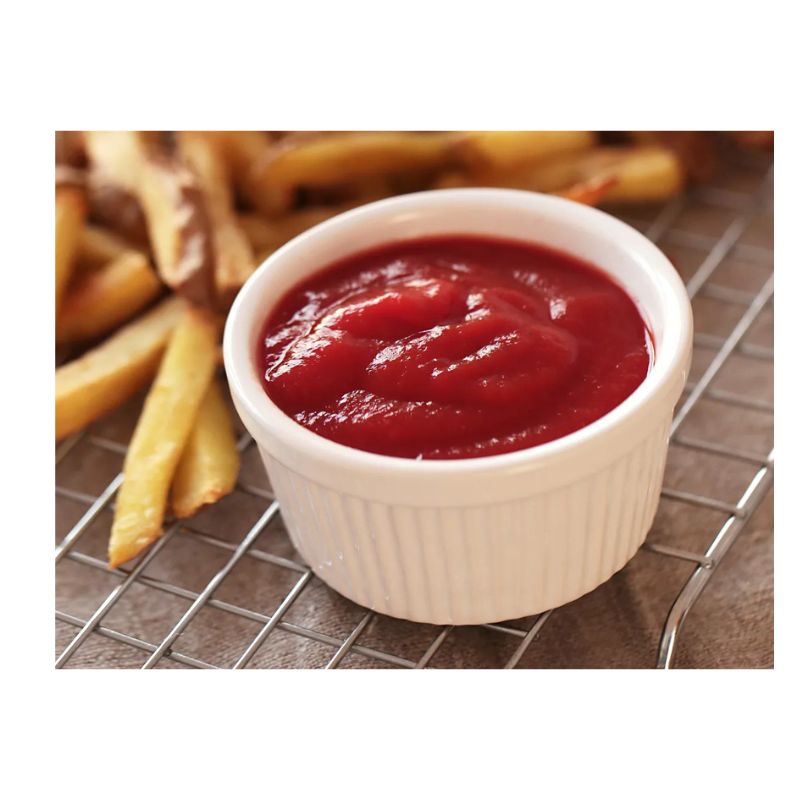 Pote de ketchup ao lado de batatas fritas
