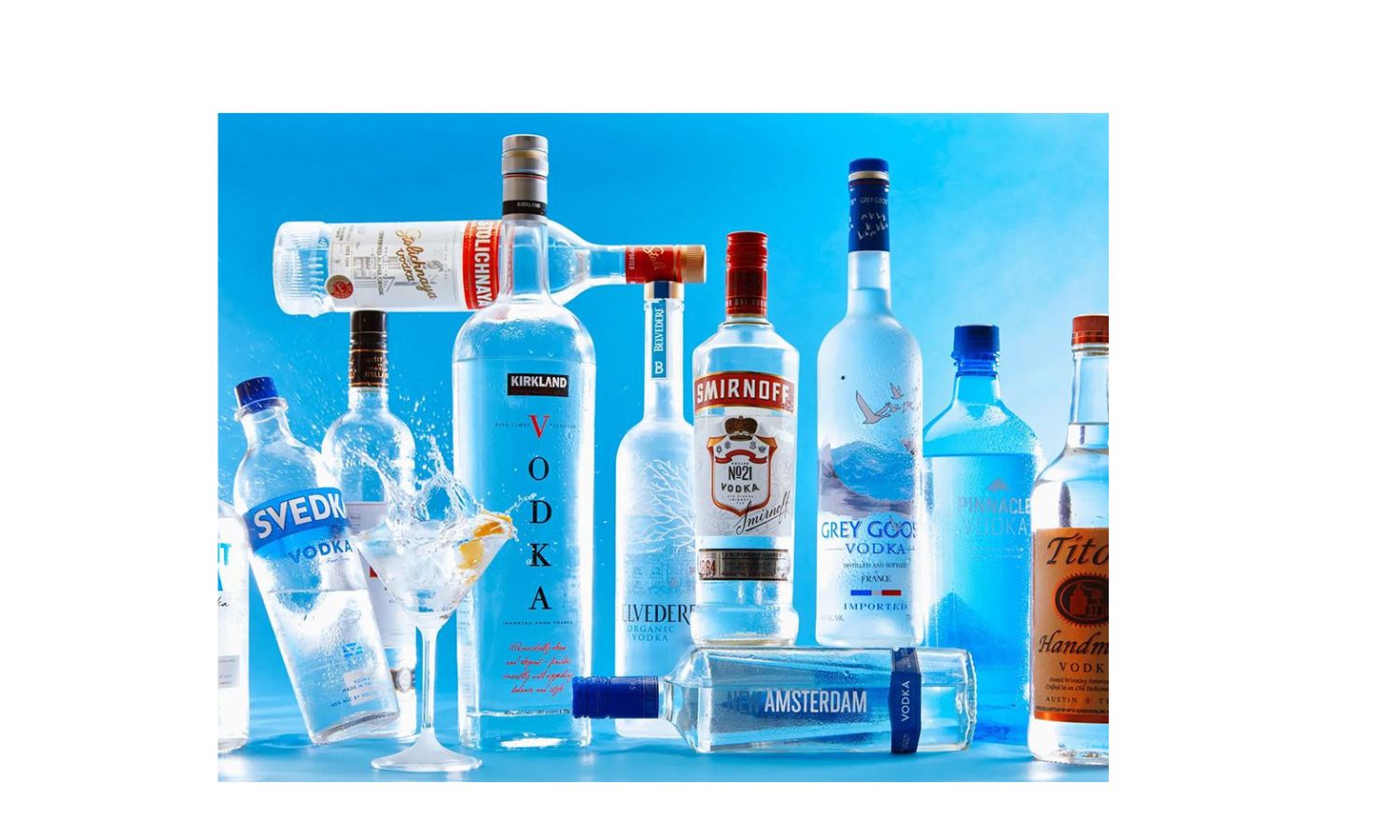 Garrafas de vodka sobre balcão com gelo e taças